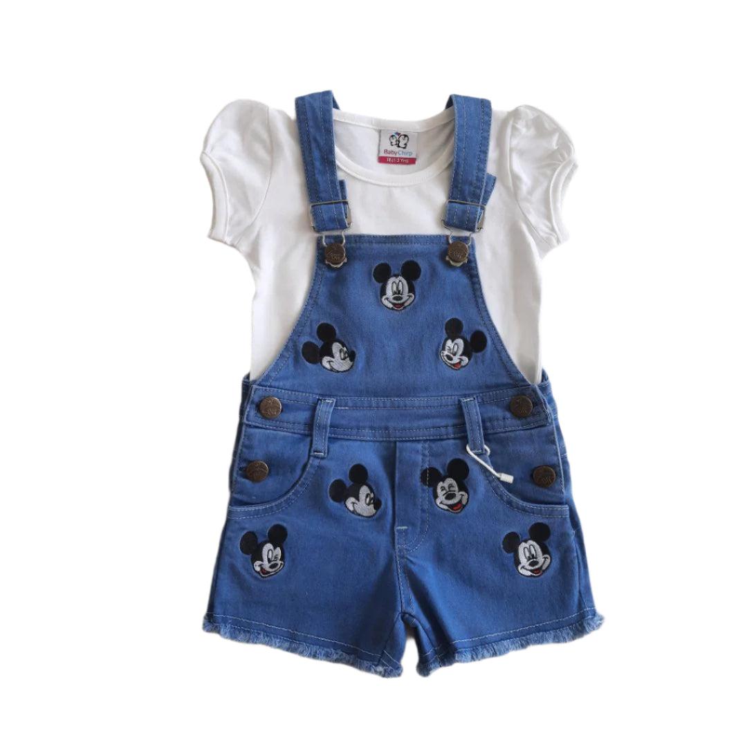 Blue denim overalls with Mickey Mouse patches on a white shirt against a light gray background